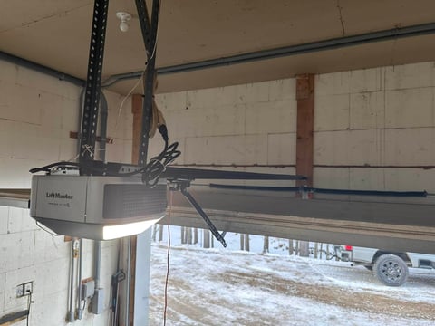 LiftMaster garage door opener mounted on ceiling of garage interior, showing motor unit and mechanical components